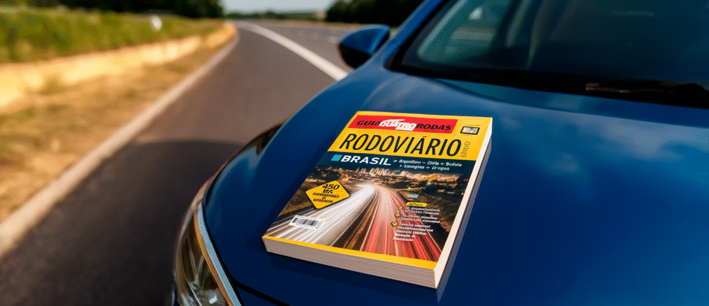 Foto do antigo Guia Quatro Rodas de papel sobre um carro, simbolizando a forma manual de planejar rotas antes da chegada de tecnologias como o Waze e a inteligência artificial, tema central do artigo.